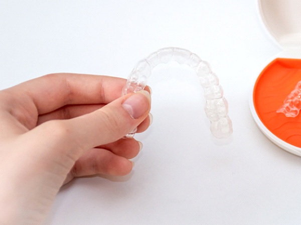 Person’s hand holding Vivera orthodontic retainer