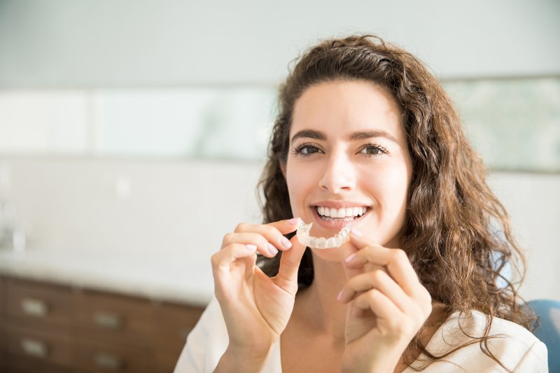 female patient inserting Invisalign aligner
